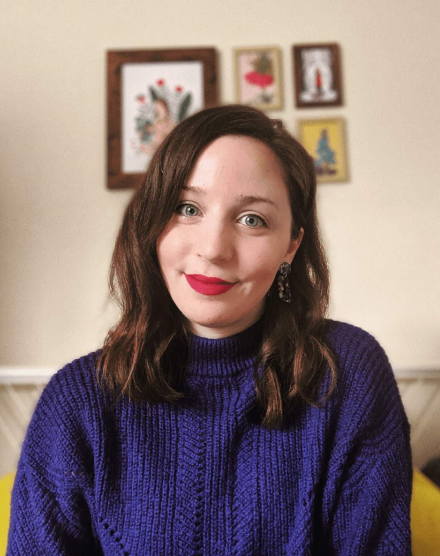 A white woman with long brown hair and blue eyes, in a blue jumper.